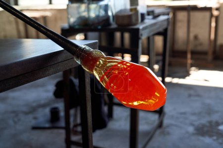 Foto de Vidrio líquido calentado en la punta de la cerbatana en proceso de fabricación de jarrón de narguile en el taller - Imagen libre de derechos