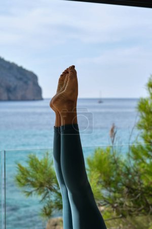 Téléchargez les photos : Cultiver femelle méconnaissable en leggings pratiquant le yoga à Salamba Shirshasana sur la terrasse d'été - en image libre de droit