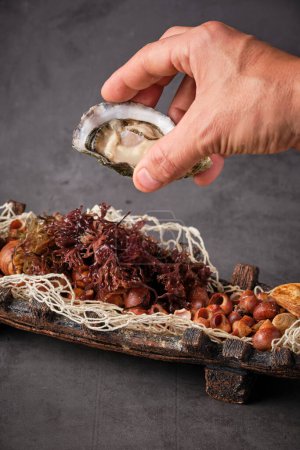 Foto de Desde arriba de ostra sabrosa en cáscara servida en plato con diversos ingredientes de mariscos en restaurante - Imagen libre de derechos