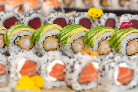 Photo for Close up of different assorted varieties of delicious and appetizing sushi rolls made with fresh fish cooked rice and chopped vegetables - Royalty Free Image