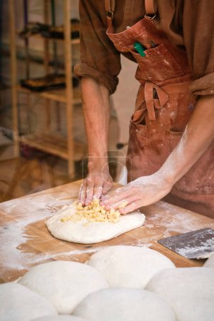 Téléchargez les photos : Jeune boulanger masculin préparant la pâte pour la fabrication du pain. Photo de haute qualité - en image libre de droit