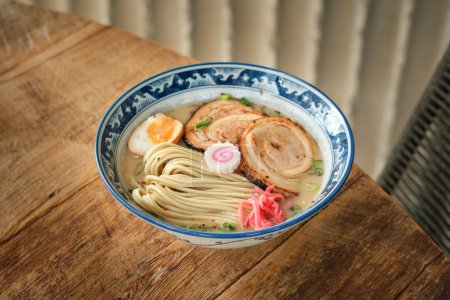 Photo for From above tasty ramen served for lunch in ornamental bowl on lumber table in restaurant - Royalty Free Image