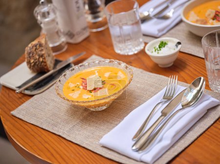 Téléchargez les photos : De dessus purée de soupe savoureuse avec microgreens servis sur la table avec couverts sur serviette sur table en bois - en image libre de droit