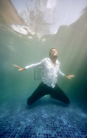 Photo for Underwater view of mature male in clothes drowning in swimming pool feeling despair - Royalty Free Image