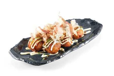 Téléchargez les photos : Assiette avec des boules de poulpe de blé frit japonais de Takoyaki garnies de flocons de bonite isolés sur fond blanc - en image libre de droit
