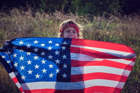 Foto de Alegre niño preadolescente sosteniendo la bandera de Estados Unidos de América en manos extendidas - Imagen libre de derechos