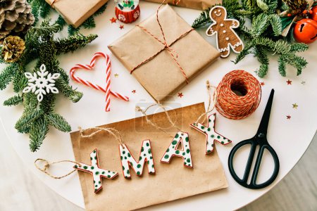 Foto de Composición de vista superior de cajas de regalo de Navidad hechas a mano colocadas en la mesa con varias decoraciones y tijeras - Imagen libre de derechos