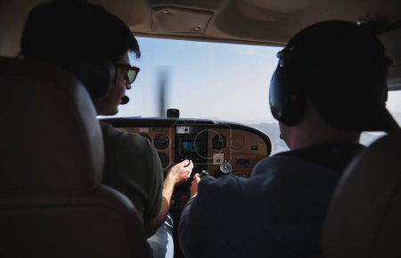Photo for Stock photo of young man with aviation headset piloting light aircraft. - Royalty Free Image