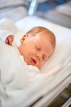 Photo for Newborn baby sleeping in its hospital crib - Royalty Free Image