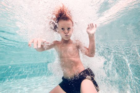 Photo for Underwater shot of adorable kid with naked torso looking at camera while grimacing - Royalty Free Image