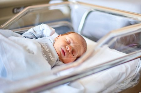 Newborn baby sleeping in its hospital crib