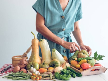 Téléchargez les photos : Cultivez une femelle anonyme en préparant des légumes crus frais et des produits d'épicerie sur la table de cuisine avant la cuisson. - en image libre de droit