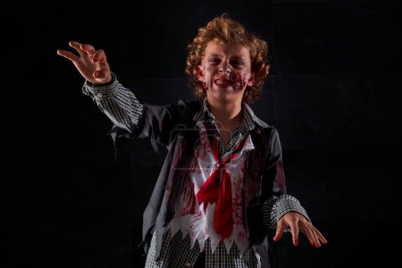 Téléchargez les photos : Visage de garçon avec maquillage zombie, personnage d'Halloween, expression de zombie - en image libre de droit