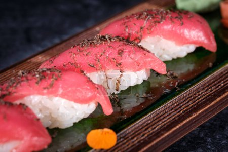 Photo for Yummy Japanese sushi nigiri with fresh fish and rice decorated with conserved ginger and wasabi and thin slice of radish and lime - Royalty Free Image