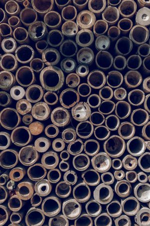 Photo for Full frame of textured background of pile of brown and gray bamboo pipes arranged in rows - Royalty Free Image