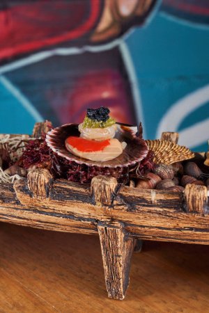 Téléchargez les photos : Scallop servi dans un bateau décoratif en bois avec coquillages et accessoires marins placés sur la table près du mur avec graffiti dans la cuisine - en image libre de droit