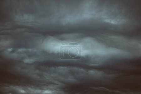 Téléchargez les photos : Cadre complet de nuages gris pelucheux flottant haut dans l'air sur un ciel sombre et dramatique dans la nature par temps couvert et sombre - en image libre de droit