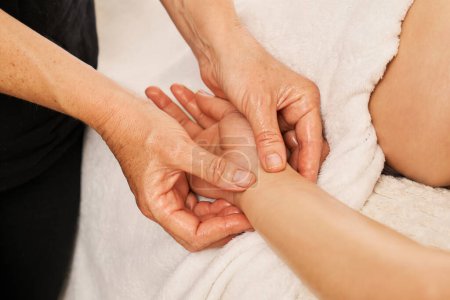 Téléchargez les photos : Thérapeute massant les mains d'une femme. Massage des mains de décontraction pour soulager la tension et la douleur - en image libre de droit