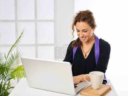 Téléchargez les photos : Femme cadre travaillant sur l'ordinateur à partir d'un bureau immobilier - en image libre de droit