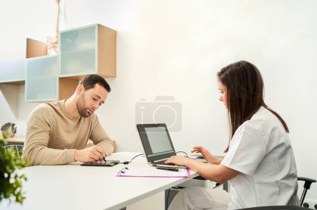 Photo for The physical therapist and the patient fill out a patient form. - Royalty Free Image
