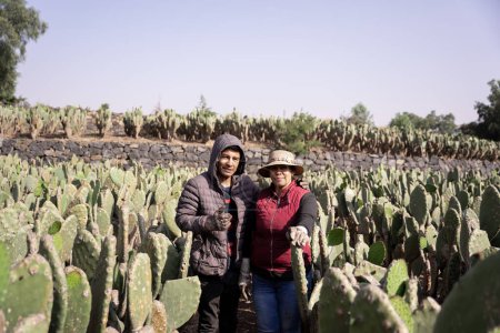 Photo for Mother and son are posing in a nopal field while working during the harvest. Concept of mexican agriculture - Royalty Free Image
