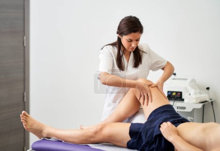 Foto de Fisioterapeuta que trata la rodilla del paciente - Imagen libre de derechos