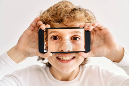 Foto de Niño posando con su teléfono móvil y fotos hechas de partes de su cara - Imagen libre de derechos