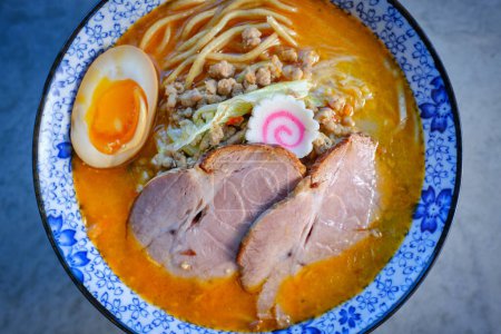 Photo for From above of char siu pork in palatable Asian soup with boiled egg and wheat noodles in bowl served on table - Royalty Free Image