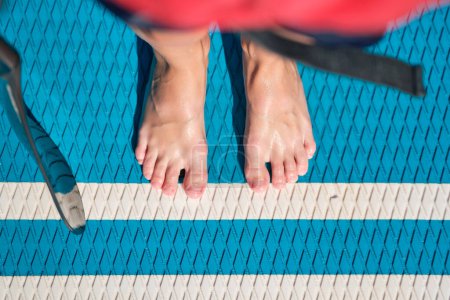 Téléchargez les photos : Vue du dessus d'une personne méconnaissable menant un mode de vie sain et pratiquant la natation en paddle le week-end jour d'été - en image libre de droit