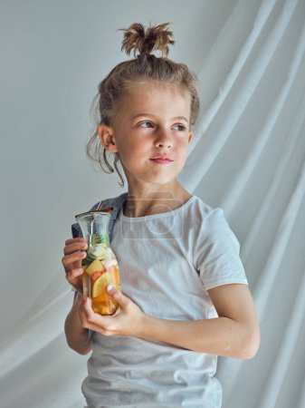 Photo for Adorable boy with glass of homemade drink made of various citrus fruits mint and cinnamon - Royalty Free Image
