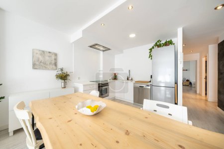 Foto de Interior de cocina contemporánea y comedor con muebles blancos diseñados en estilo minimalista en apartamento - Imagen libre de derechos