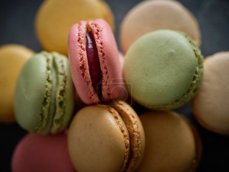 Photo for From above closeup pile of delicious sweet round colorful macaroons with different flavors stacked together on table in light room - Royalty Free Image