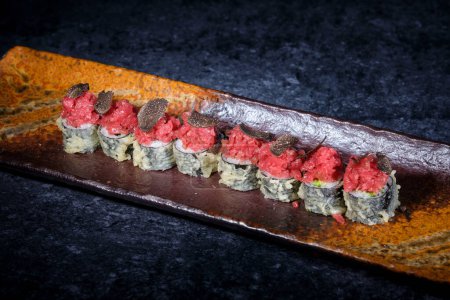 Foto de Alto ángulo de deliciosos rollos de sushi tempura con pescado fresco y trufas servidas en plato alargado - Imagen libre de derechos
