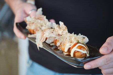 Téléchargez les photos : Photo de stock de personne non reconnue servant une délicieuse assiette de sushi avec des sauces spéciales. - en image libre de droit