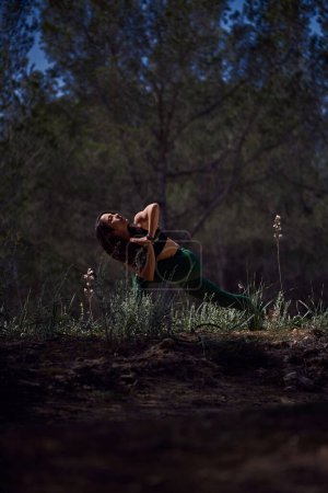 Téléchargez les photos : Full body of fit sportive femelle pratiquant chaise pivotante avec les mains pliées pendant la séance de yoga dans la nature le jour d'été - en image libre de droit