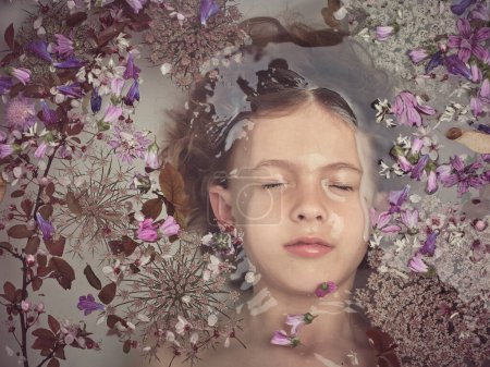 Photo for Top view of shirtless boy lying with closed eyes under water in clear bath with colorful small flowers in light bathroom - Royalty Free Image