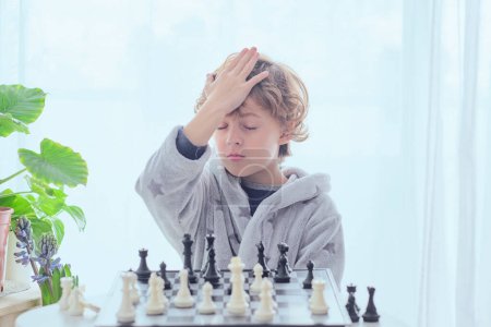 Foto de Niño preadolescente serio pensando paso y estrategia mientras juega al ajedrez y se prepara para la competencia - Imagen libre de derechos