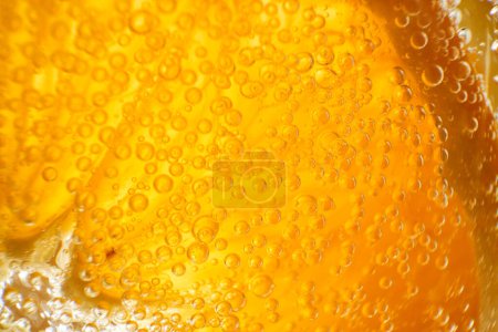 Téléchargez les photos : Gros plan plein cadre de tranche d'orange ronde en verre avec gin alcoolique rafraîchissant transparent et cocktail tonique avec de petites bulles - en image libre de droit