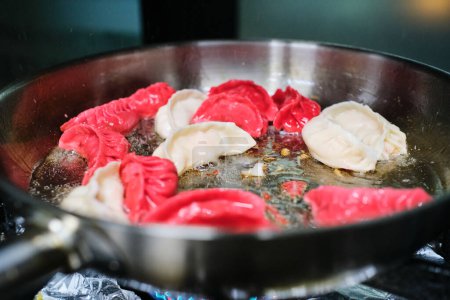 Téléchargez les photos : Gros plan de boulettes chinoises traditionnelles placées dans une poêle en métal en cours de cuisson dans de l'huile bouillante - en image libre de droit