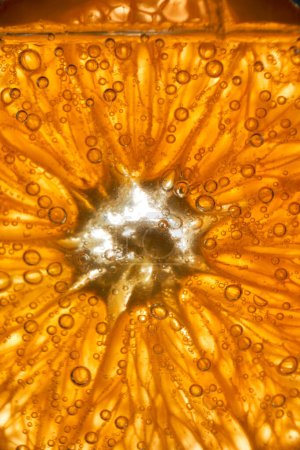 Foto de Primer plano marco completo de rodaja de naranja fresca con pulpa en vidrio transparente con ginebra gaseosa y bebida tónica en sala de luz - Imagen libre de derechos