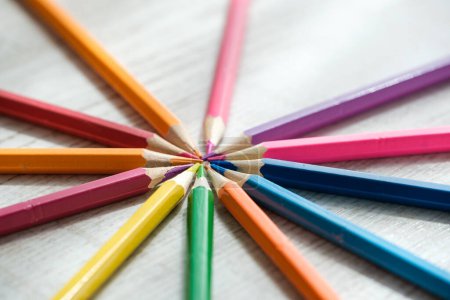 Photo for Coloured pencils arranged in a circle on Coloured pencils arranged in a circle on a wooden background. High quality photo - Royalty Free Image