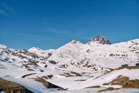 Foto de Espectacular paisaje de ásperas colinas rocosas cubiertas de nieve blanca situadas bajo el cielo azul sin nubes - Imagen libre de derechos