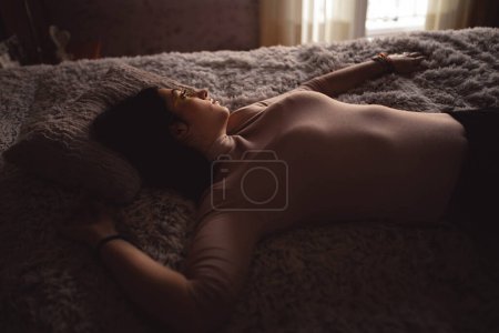 Téléchargez les photos : Jeune femme couchée sur le lit - en image libre de droit