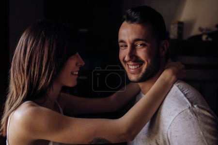 Téléchargez les photos : Couple heureux assis sur le lit - en image libre de droit