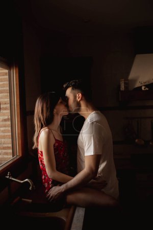 Foto de Feliz pareja besándose en la cocina - Imagen libre de derechos