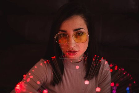 Foto de Mujer joven con luces de hadas en la oscuridad - Imagen libre de derechos