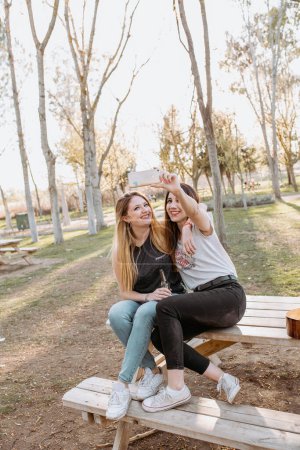 Foto de Mujeres sonrientes tomando selfie en el parque - Imagen libre de derechos