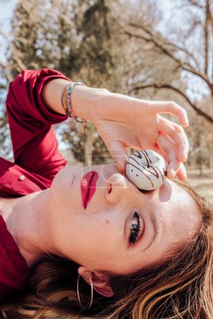 Téléchargez les photos : Femme regardant à travers le trou des beignets sur le pique-nique - en image libre de droit