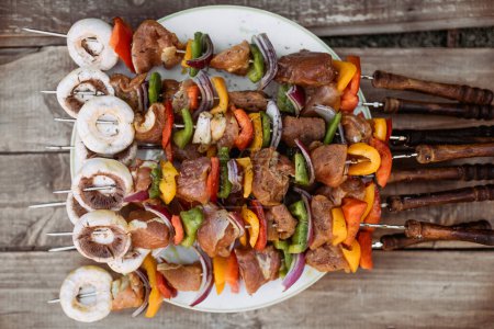 Téléchargez les photos : Vue du dessus de l'assiette avec brochettes bâtonnets de porc avec légumes du barbecue - en image libre de droit