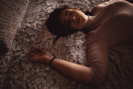 Téléchargez les photos : Jeune femme couchée sur le lit - en image libre de droit